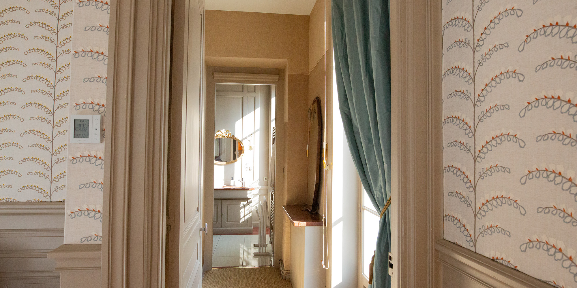 Enfilade des pièces : chambre, garde-robe, salle de bain. Détail des textiles posés aux murs.
